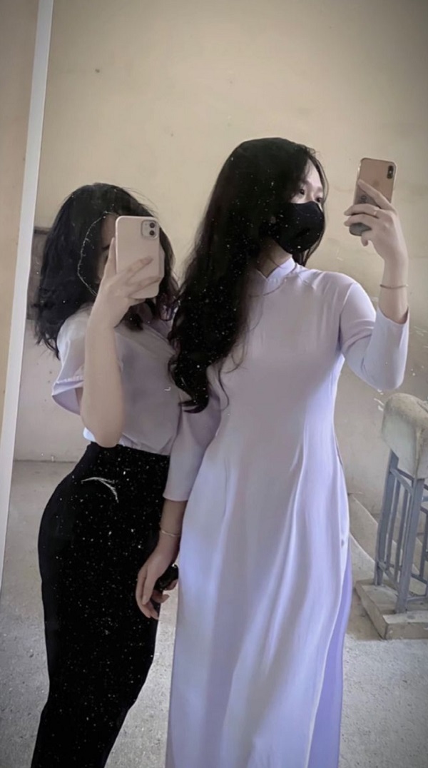 2 nữ sinh đeo khẩu trang mặc áo dài chụp ảnh trước gương