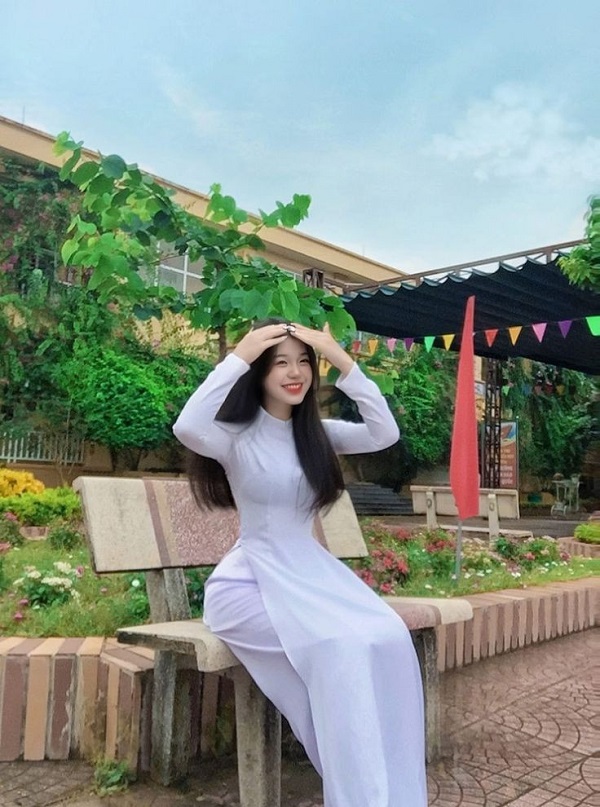 Cô gái ngồi bên ghế đá, tóc xõa tự nhiên