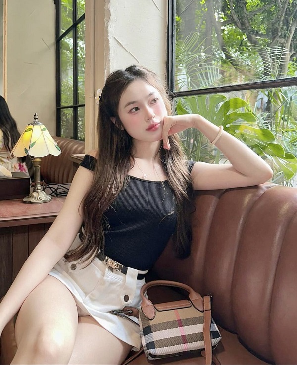 Gái xinh mặc váy ngắn ngồi bên khung cửa sổ