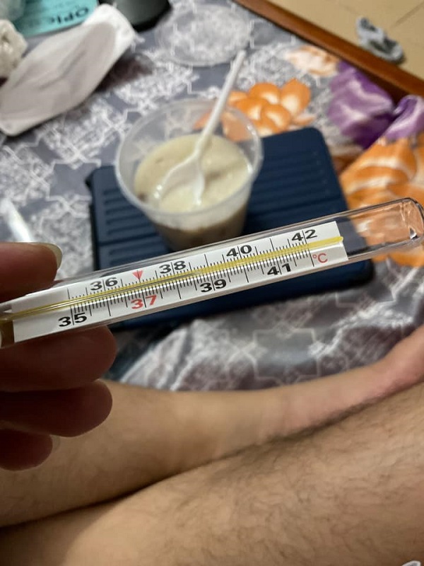 Hình ảnh nhiệt kế báo sốt 39 độ trên tay
